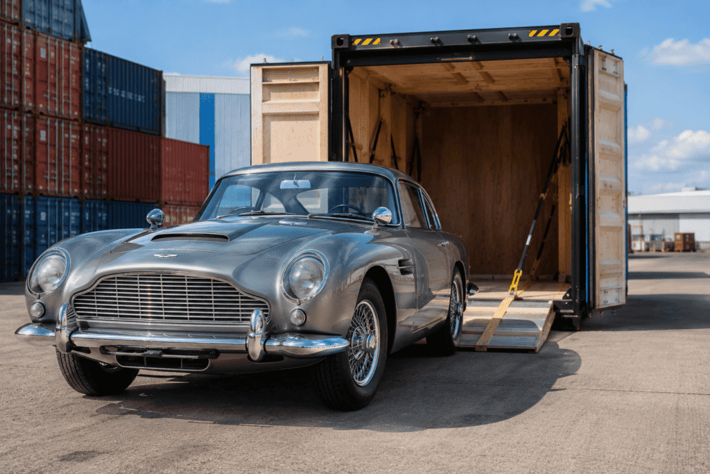 Enclosed vehicle shipping – classic sports car loading into sealed transport Enclosed vehicle shipping – classic sports car loading into sealed transport